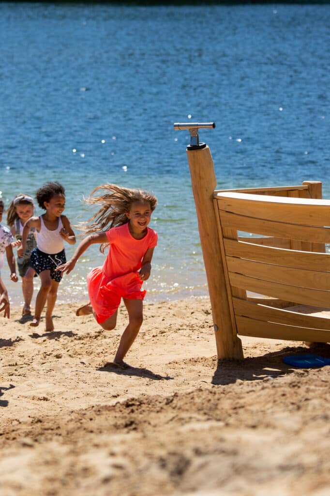 Lopende kinderen uit het water richting Robinia speelboot