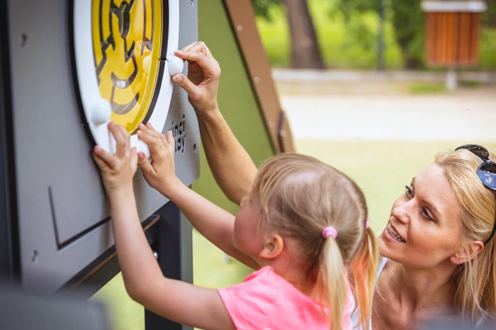 Moeder en dochter met een spelpaneel doolhofraam