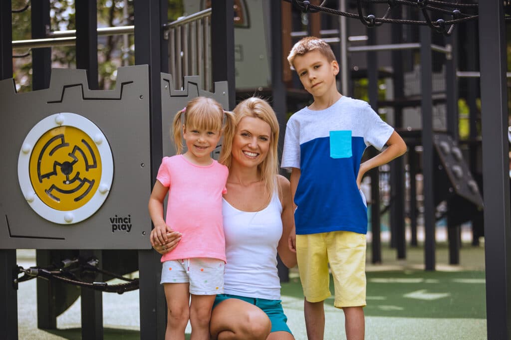 Moeder met kinderen lachend voor speelcombinatie